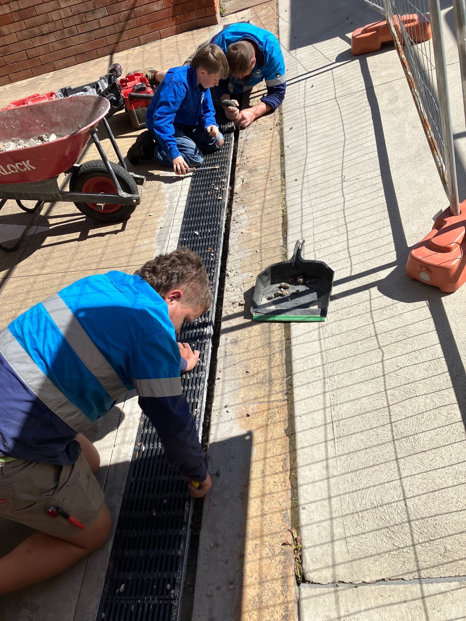 Workers Installing a Drain Cover on a Construction Site — Expert Plumbing & Solar Services Bathurst in Kelso, NSW