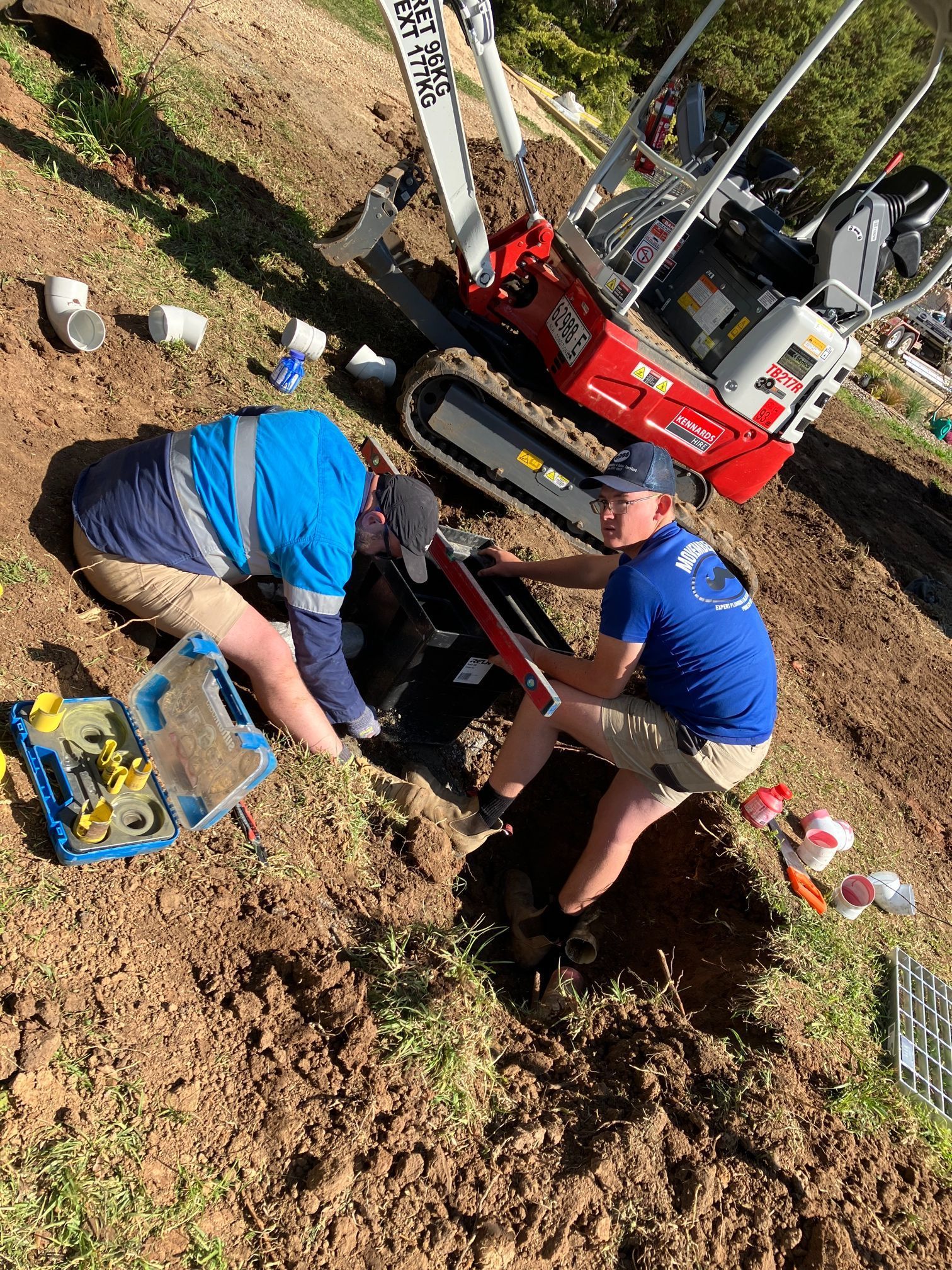 Two Workers Installing Something in a Trench Near a Small Excavator — Expert Plumbing & Solar Services Bathurst in Oberon, NSW