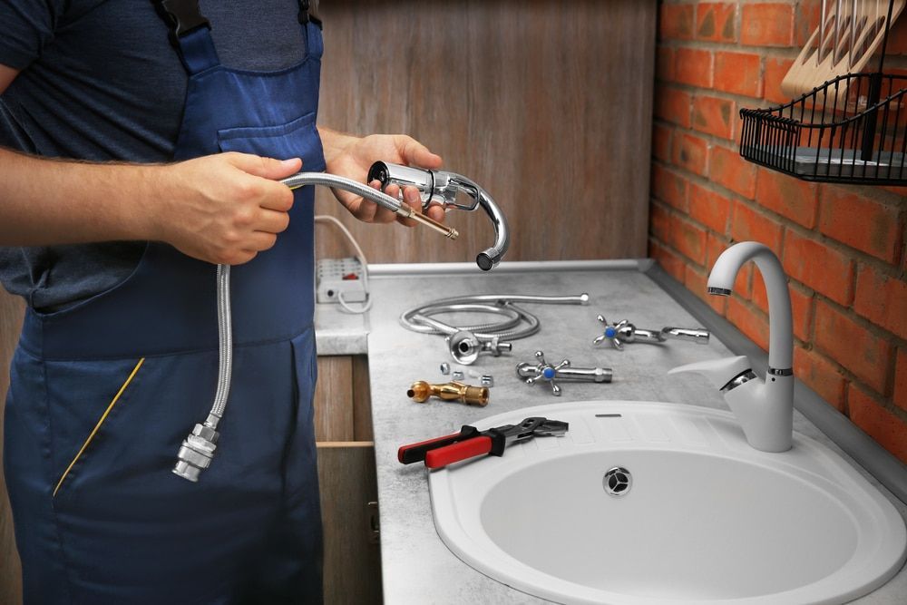 Plumber Holding Faucet Hose — Expert Plumbing & Solar Services Bathurst in Lithgow, NSW