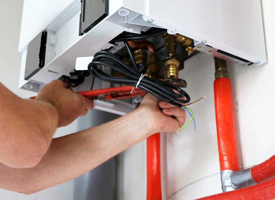 Hands of a Person Using a Wrench on a Heating System — Expert Plumbing & Solar Services Bathurst in Kelso, NSW