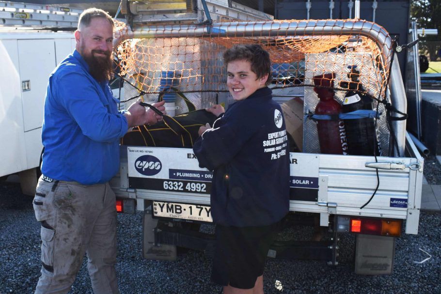 Two Men Standing Near a Plumbing Truck, One Holding a Wire — Expert Plumbing & Solar Services Bathurst in Kelso, NSW