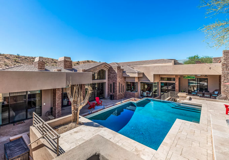 A man is working on the roof of a house next to a truck that says ' roofing ' on it