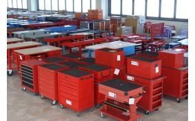 Una grande stanza piena di utensili e tavoli rossi.