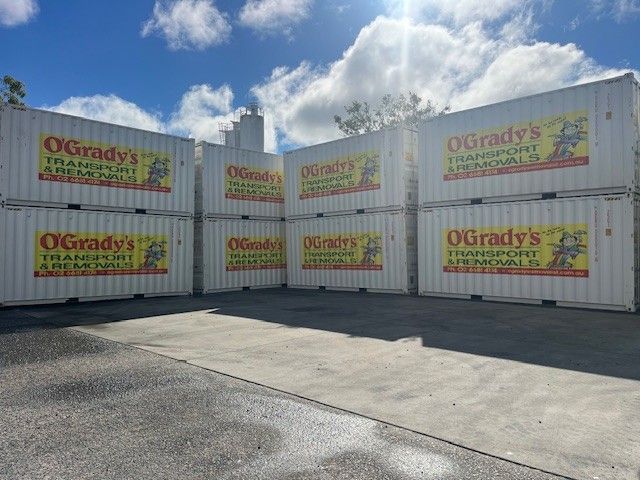 A Row of Shipping Containers Are Lined Up in a Parking Lot — O'Grady's Transport & Removals in West Ballina, NSW
