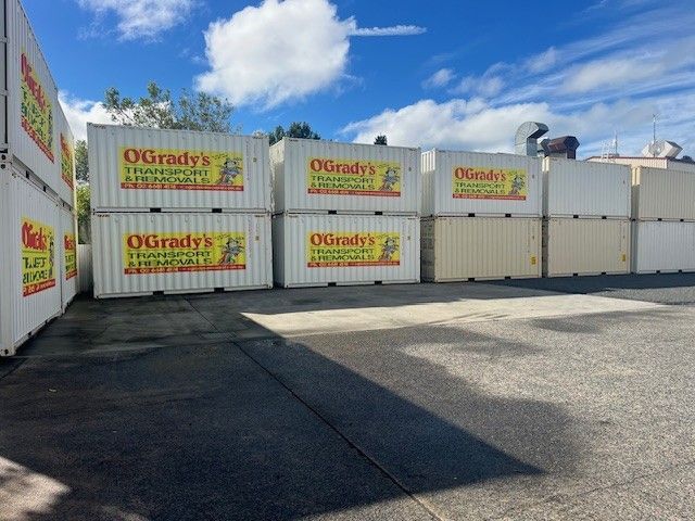 A Man is Loading a Cardboard Box Into a Moving Truck — O'Grady's Transport & Removals in West Ballina, NSW