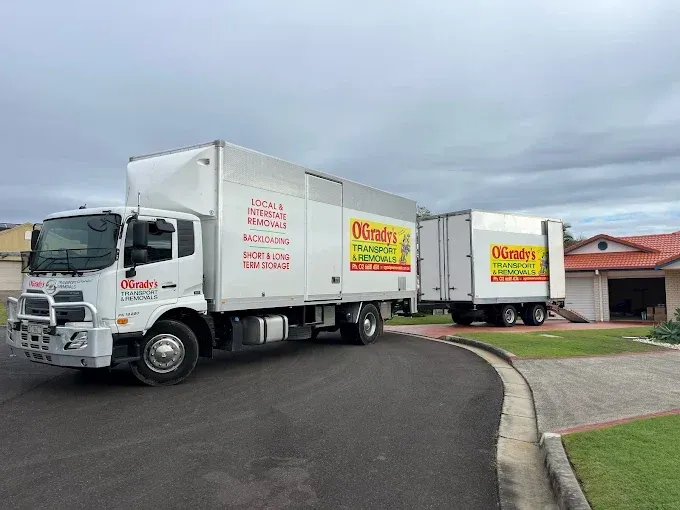 Two Trucks Are Parked Next to Each Other in a Parking Lot — O'Grady's Transport & Removals in Hervey Bay, NSW