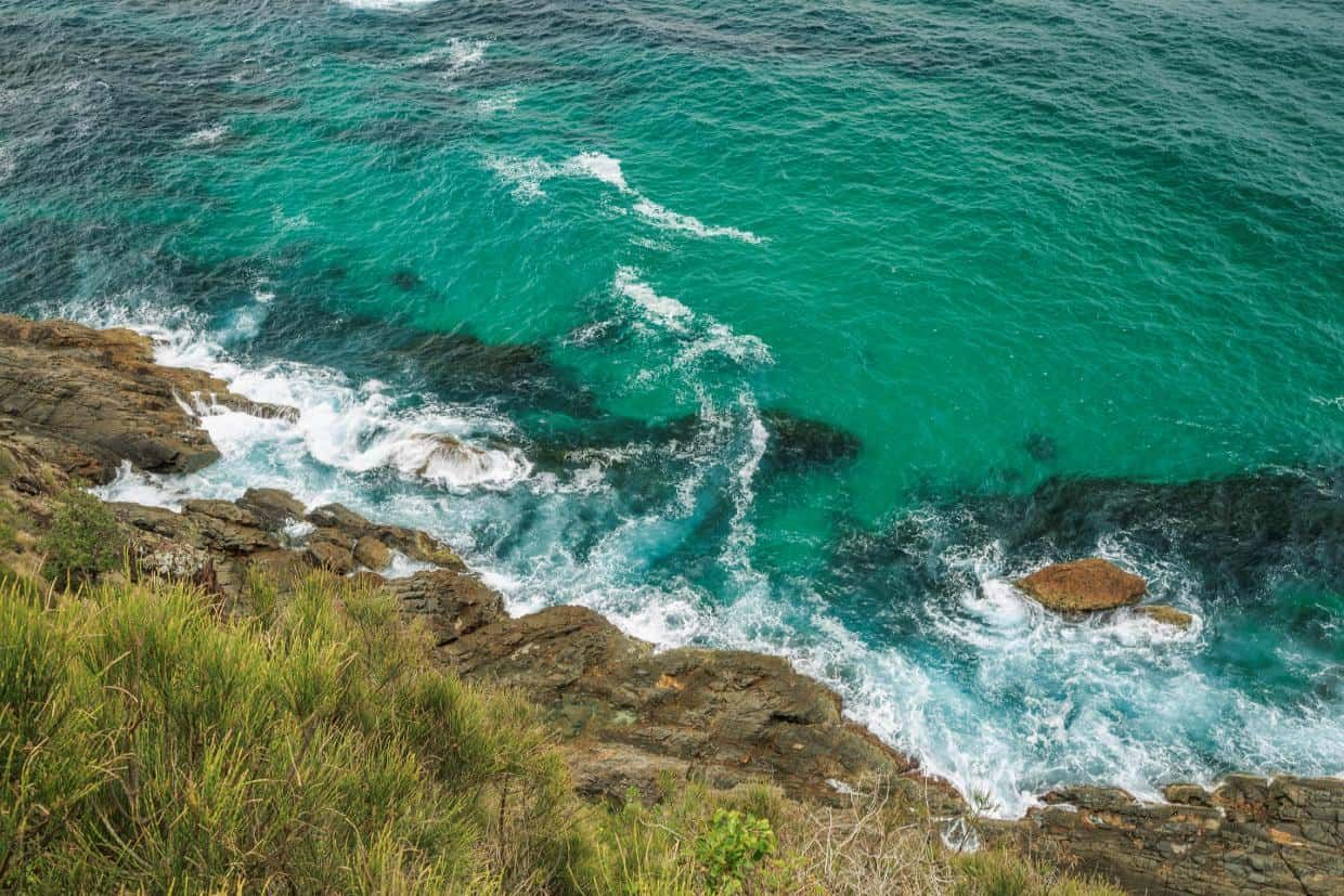 A View of the Ocean From a Cliff With Waves Crashing on the Rocks — O'Grady's Transport & Removals in Forster, NSW