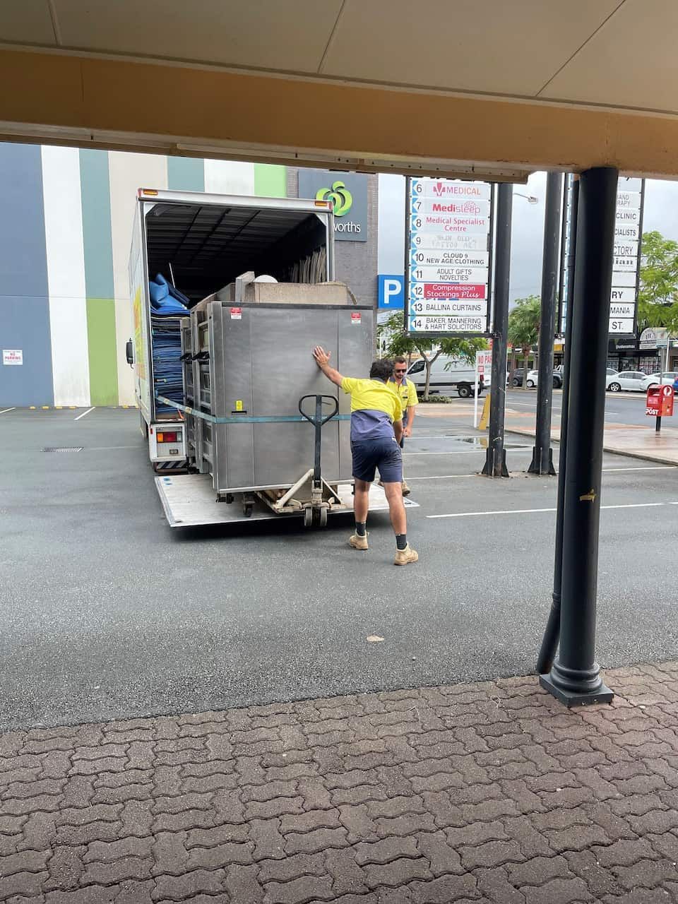 A Man is Pushing a Pallet Truck Down a Street — O'Grady's Transport & Removals in Port Macquarie, NSW