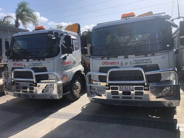 Two Trucks Are Parked Next to Each Other in a Parking Lot — O'Grady's Transport & Removals in Gold Coast, QLD