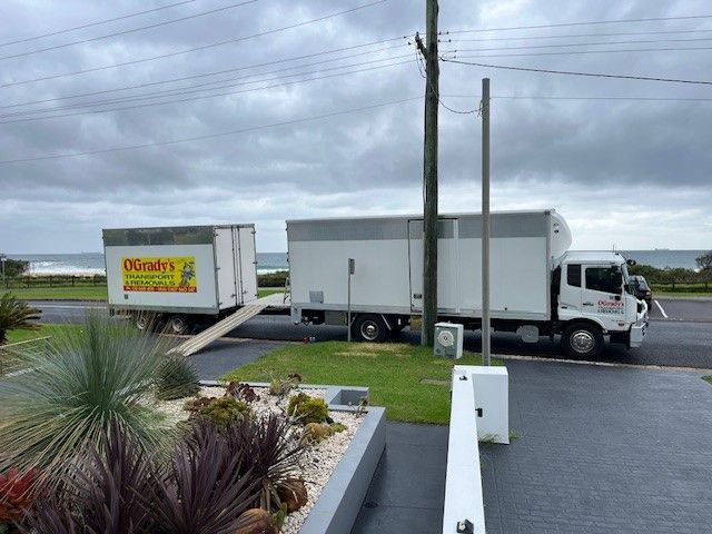 Two Moving Trucks Are Parked on the Side of the Road — O'Grady's Transport & Removals in Alstonville, NSW