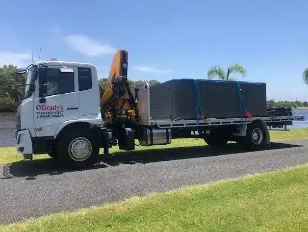 A Large Truck is Parked on the Side of the Road Next to a Body of Water — O'Grady's Transport & Removals in Alstonville, NSW