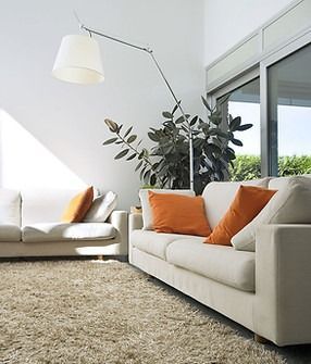 A living room with two cleaned upholstered couches and a lamp.