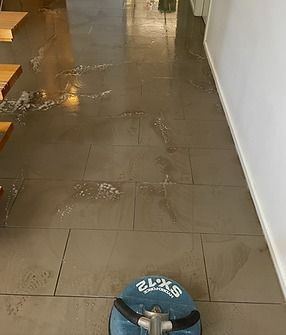 A vacuum cleaner is sitting on a tiled floor in a hallway.