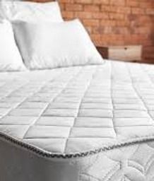 A bed with a white cleaned mattress and pillows on it.