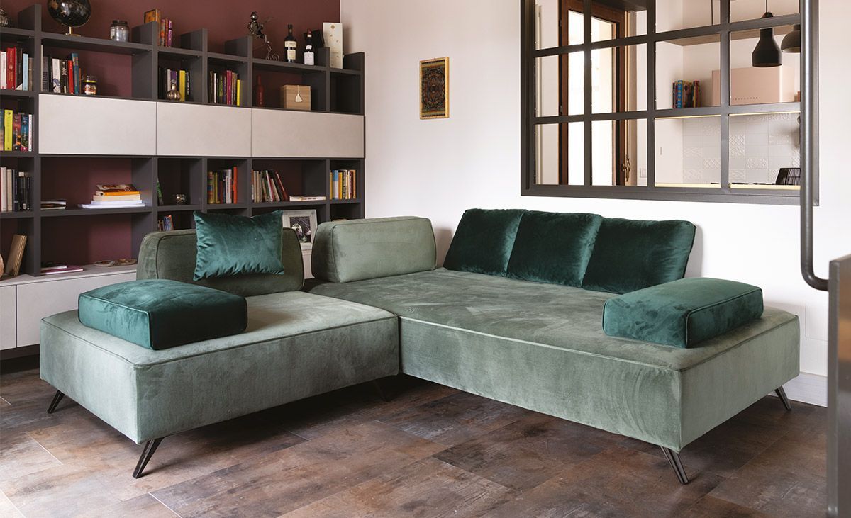 Un soggiorno con un divano componibile verde