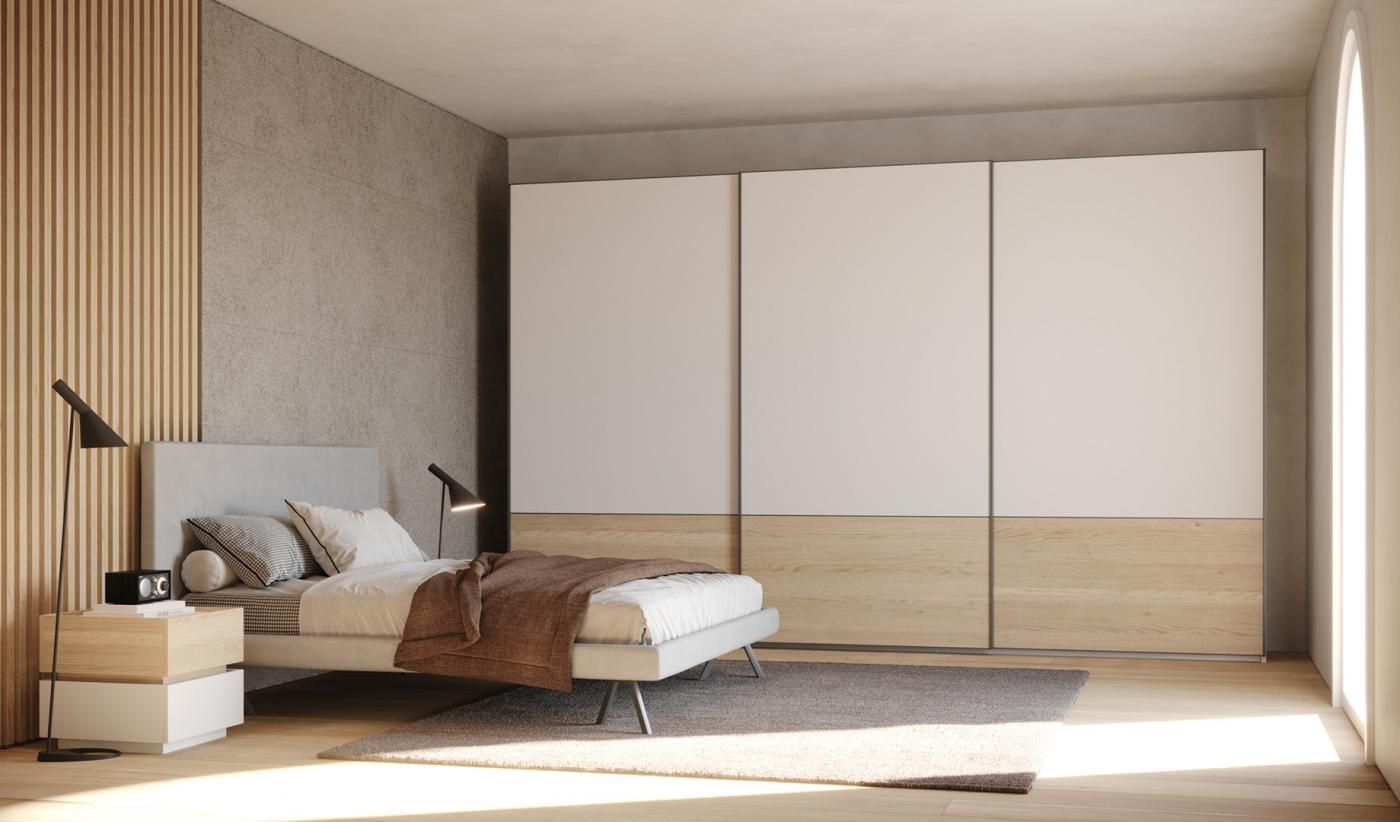 Una camera da letto con letto, comodino e armadi scorrevoli.