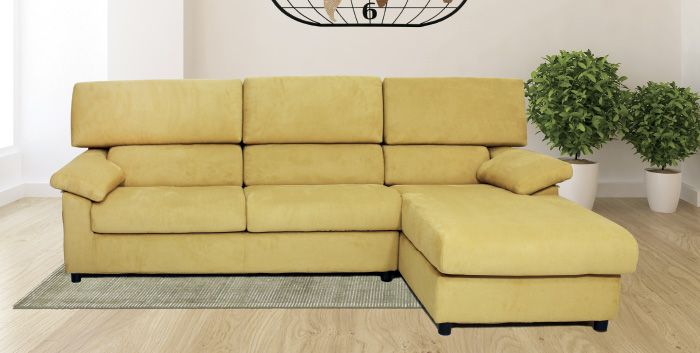 Un divano componibile giallo è appoggiato su un tappeto in soggiorno.