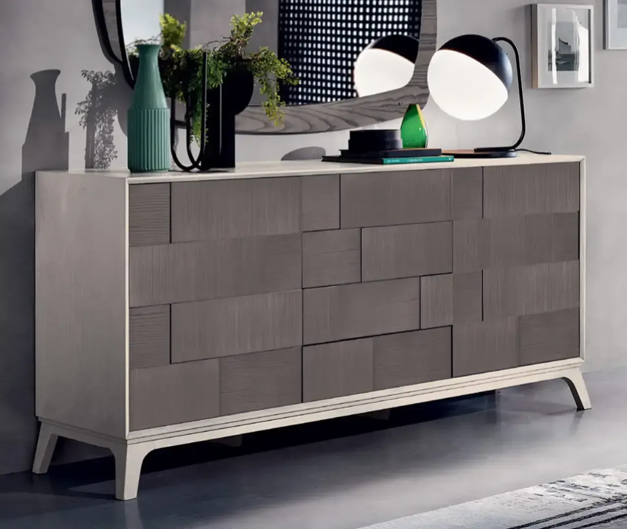 Una cassettiera con uno specchio e delle lampade sopra