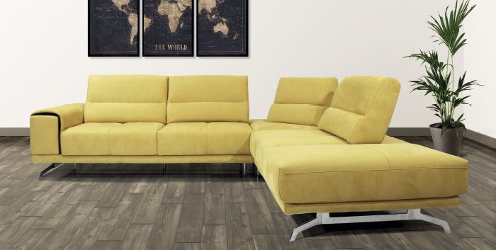 Un divano componibile giallo è posizionato in un soggiorno accanto a una pianta in vaso.