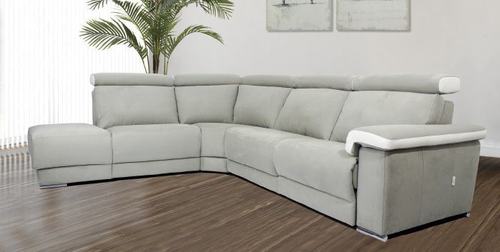 Un divano componibile bianco è appoggiato sul pavimento in legno del soggiorno.