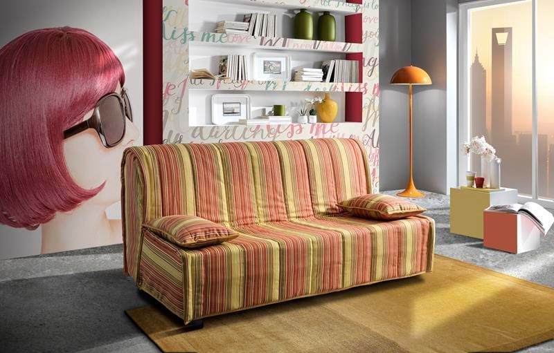Un soggiorno con un divano a righe e la foto di una donna con i capelli rosa