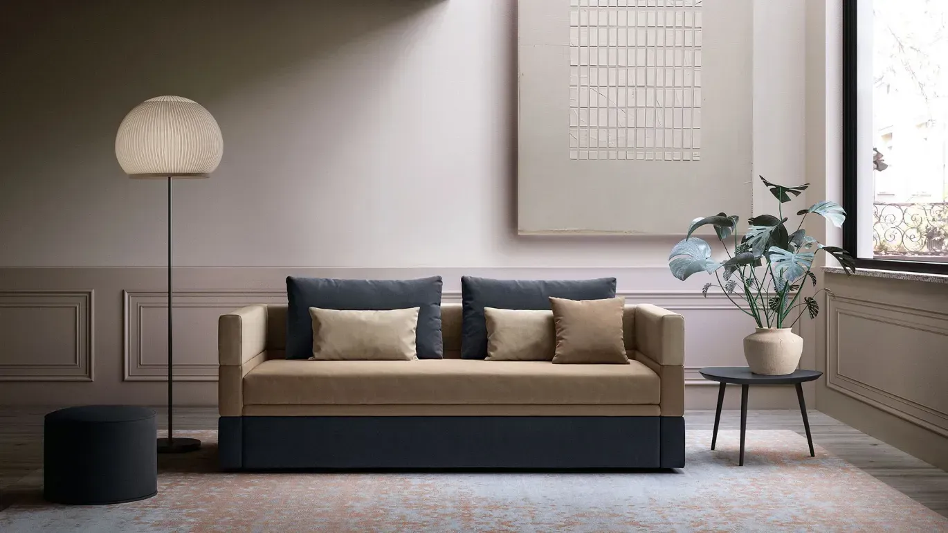 Un soggiorno con un divano e una lampada.