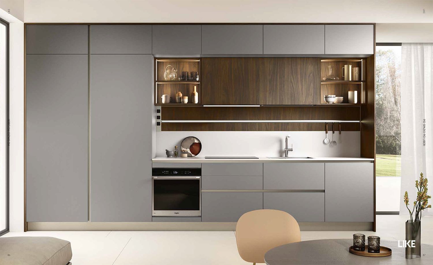 Una cucina con mobili grigi e mobili in legno e un forno in acciaio inossidabile.