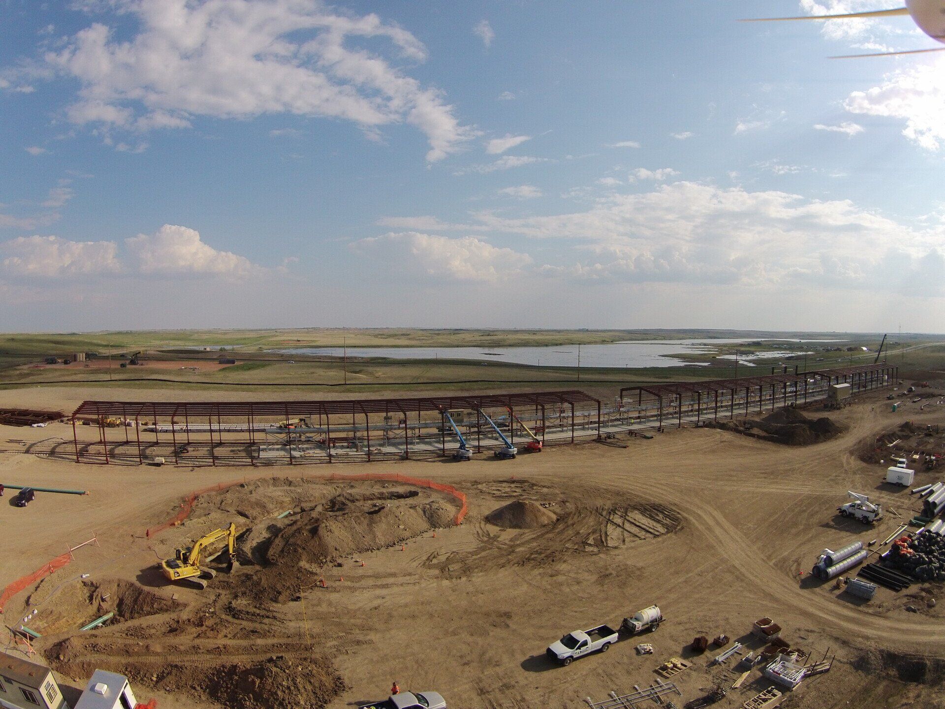 An aerial view of a construction site with a lake in the background