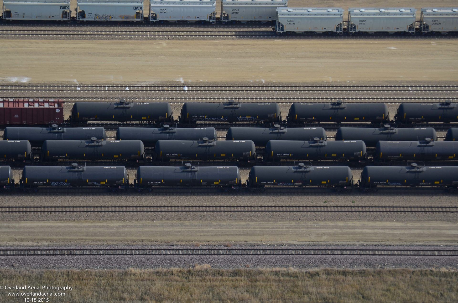 A bunch of train cars are lined up on the tracks