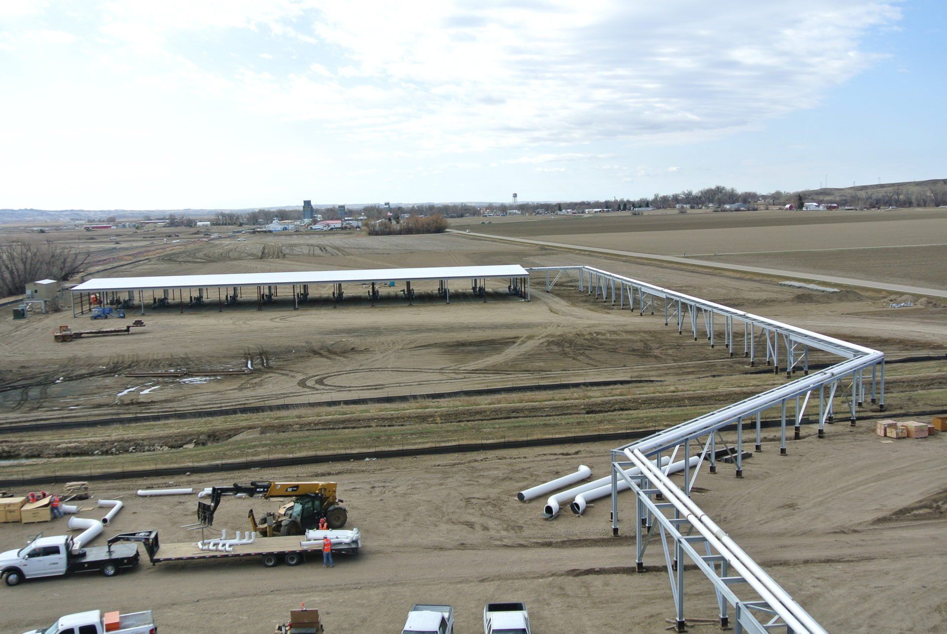 An aerial view of a construction site with pipes and trucks