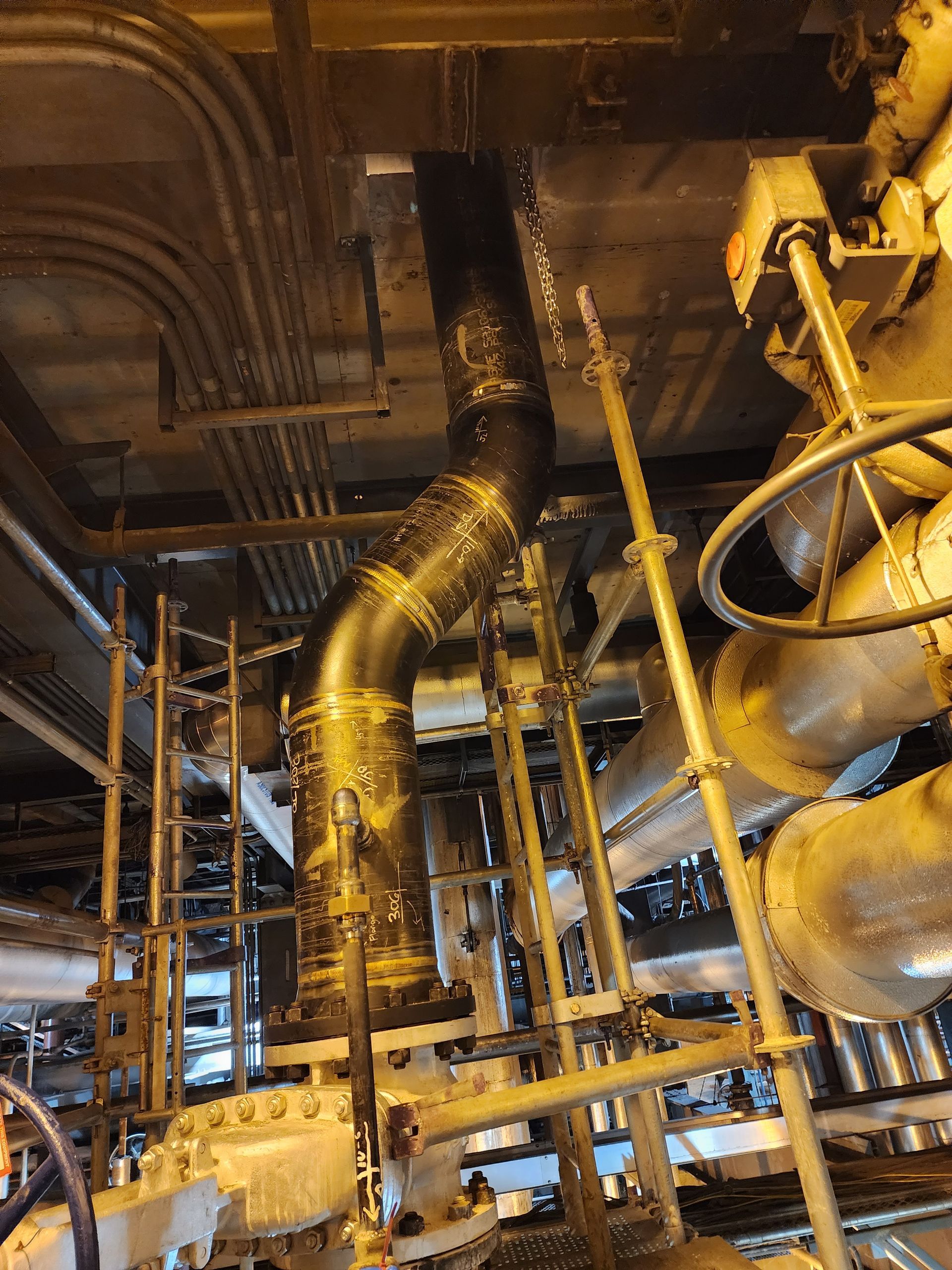 A bunch of pipes are hanging from the ceiling of a building.