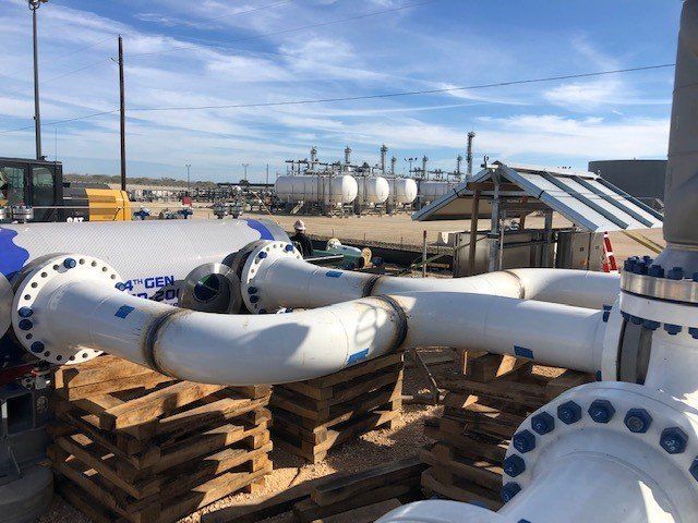 A bunch of white pipes are sitting on a wooden pallet
