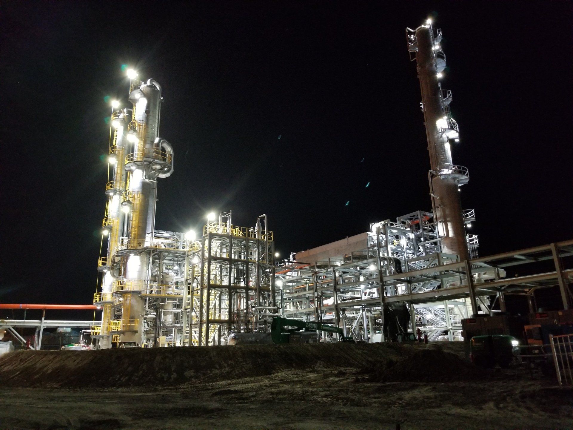 A large industrial plant is lit up at night.