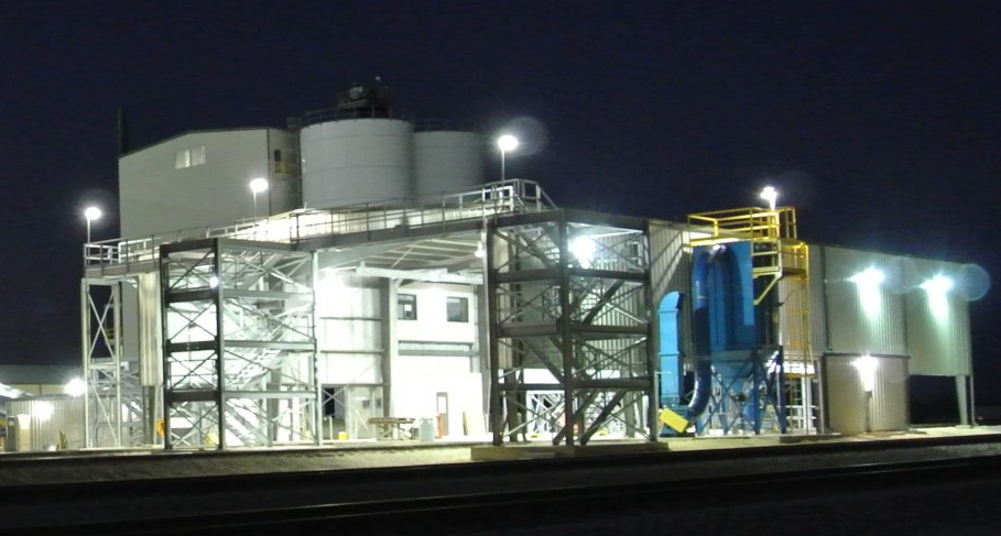 A large industrial building is lit up at night