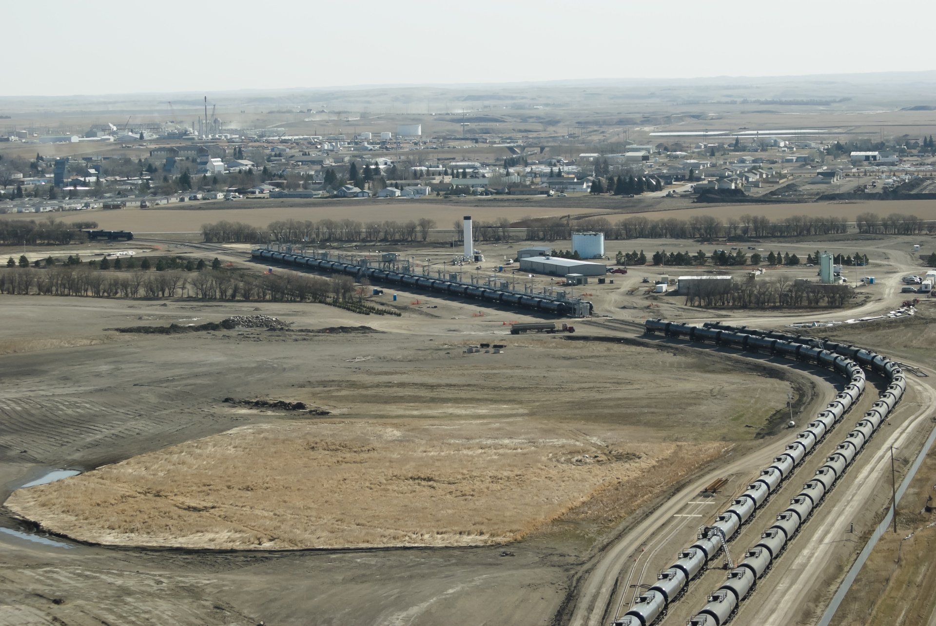 An aerial view of a train track with a city in the background