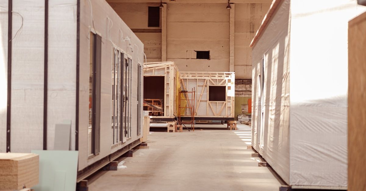 Sunlight shining into a modular construction facility. Several building sections are built inside th
