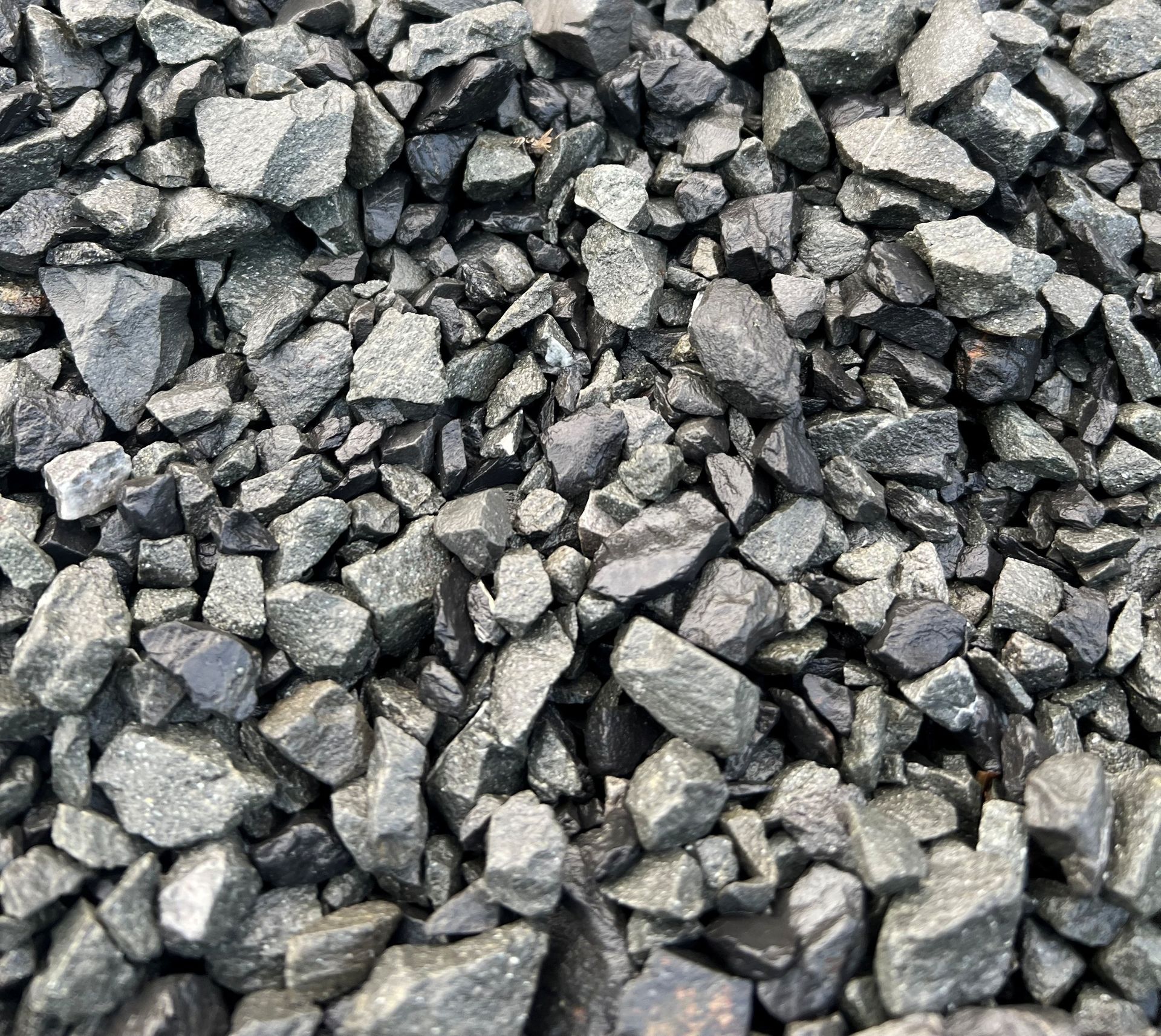 Pile of dark gray, angular gravel.