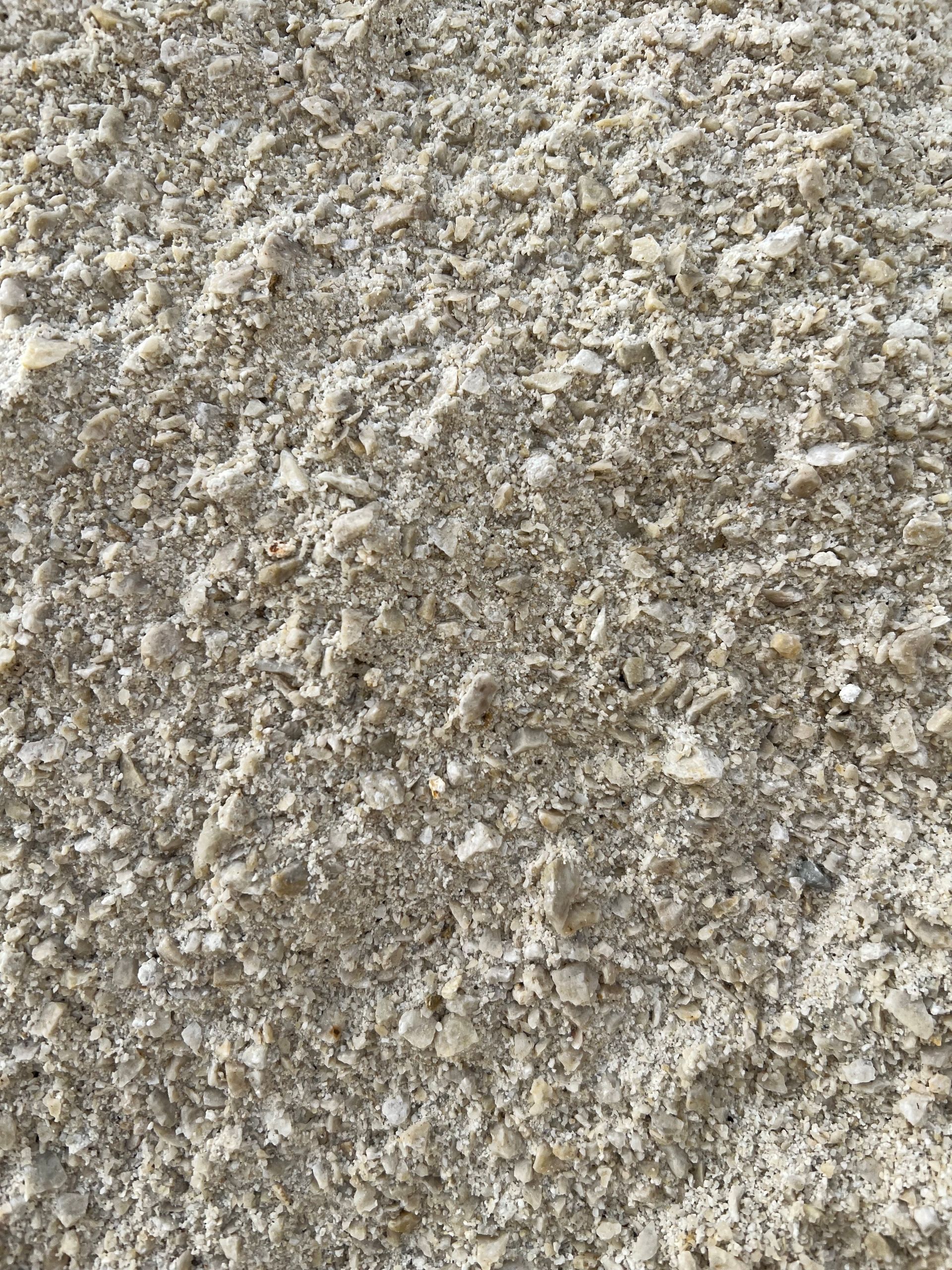 Close-up of a pile of light-colored, grainy material, possibly sand or salt.