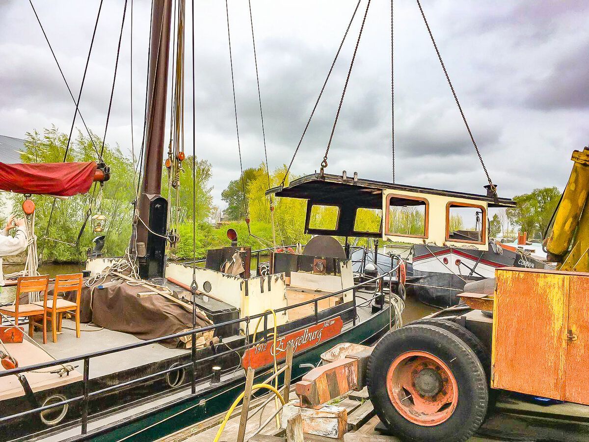 de oude roef wordt door een kraan van het schip gehesen.