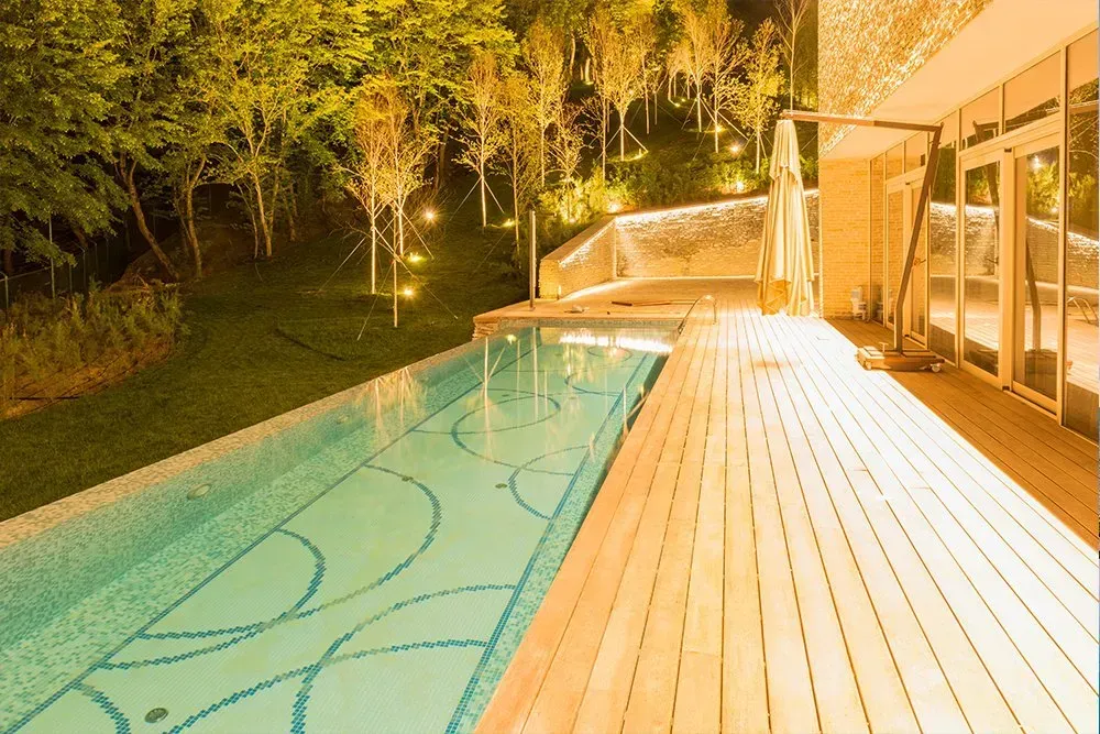 a large swimming pool with a wooden deck in front of it