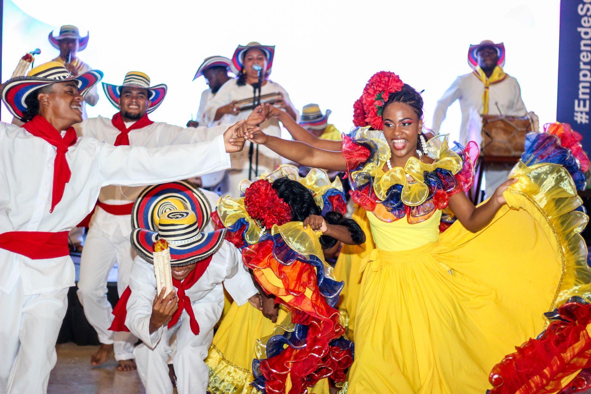 Un grupo de personas con trajes tradicionales están bailando en un escenario.