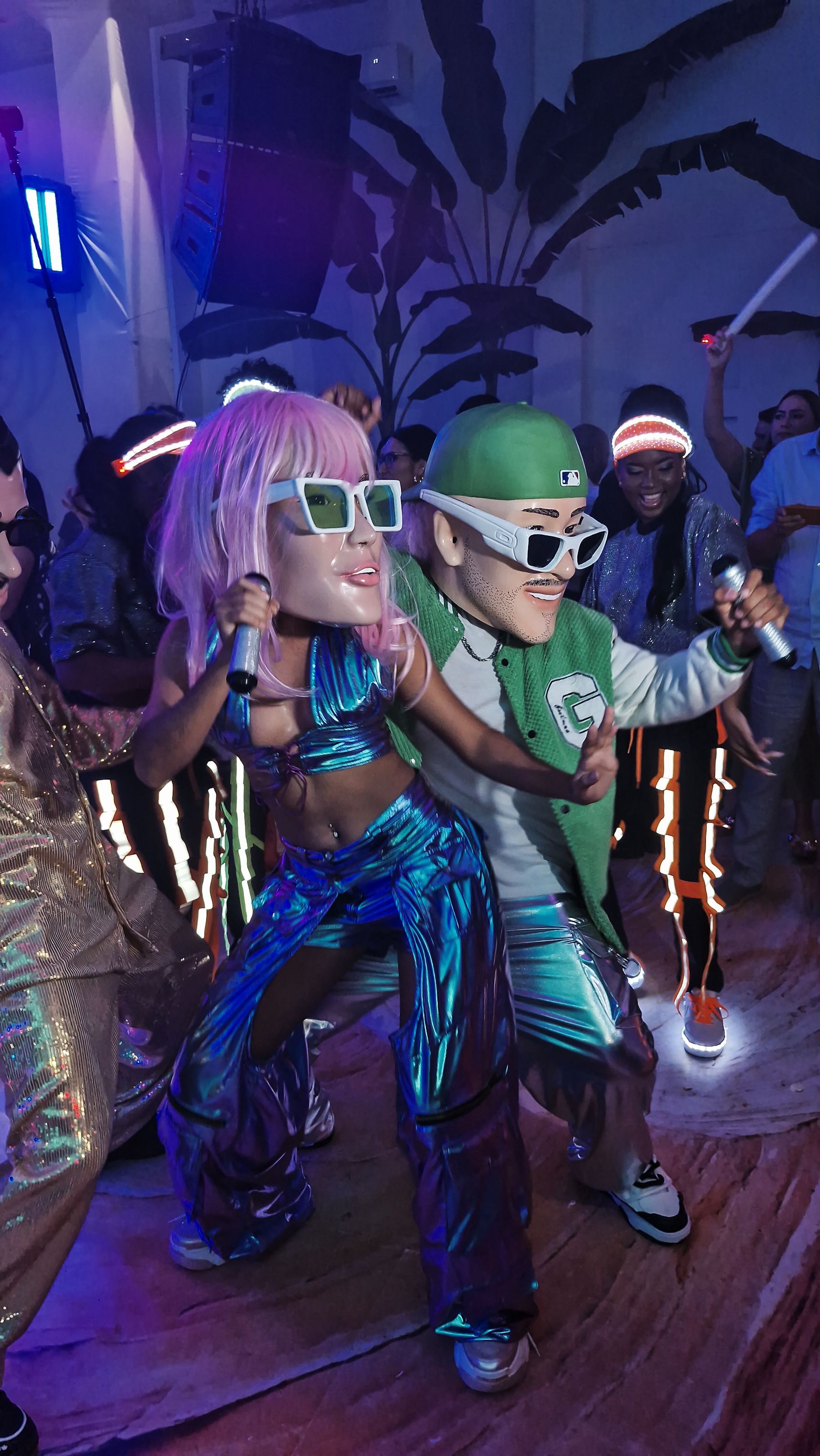 Un grupo de personas baila en un club mientras usan máscaras.