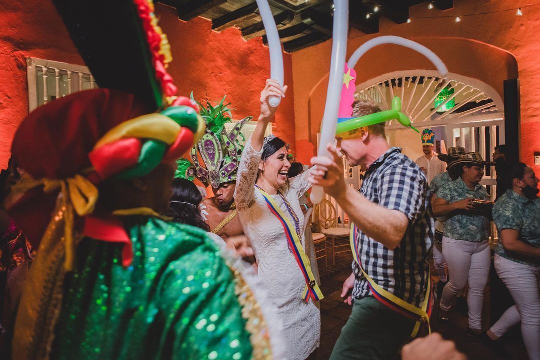 Una novia y un novio están bailando con globos en una recepción de boda.