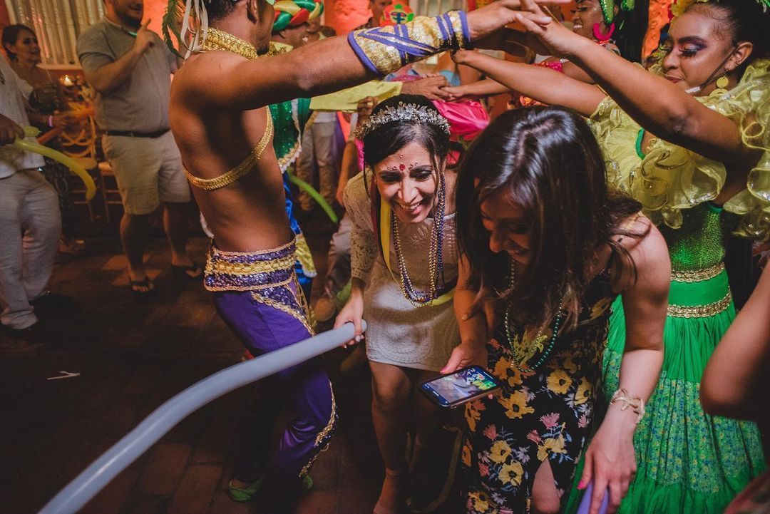 Un grupo de personas está bailando y mirando un teléfono celular.