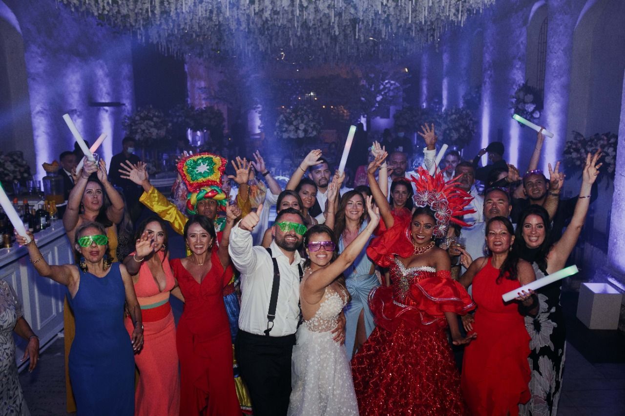 Un grupo de personas posa para una fotografía en una recepción de boda.