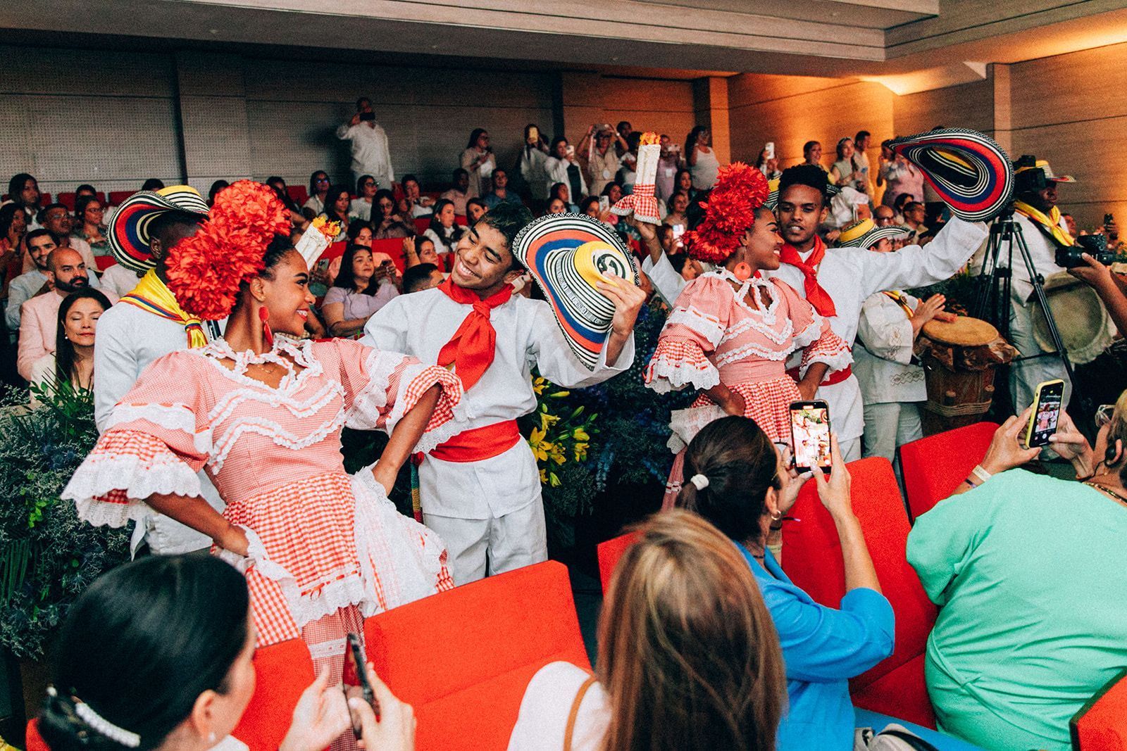 Una multitud de personas observa a un grupo de personas bailando en una habitación.