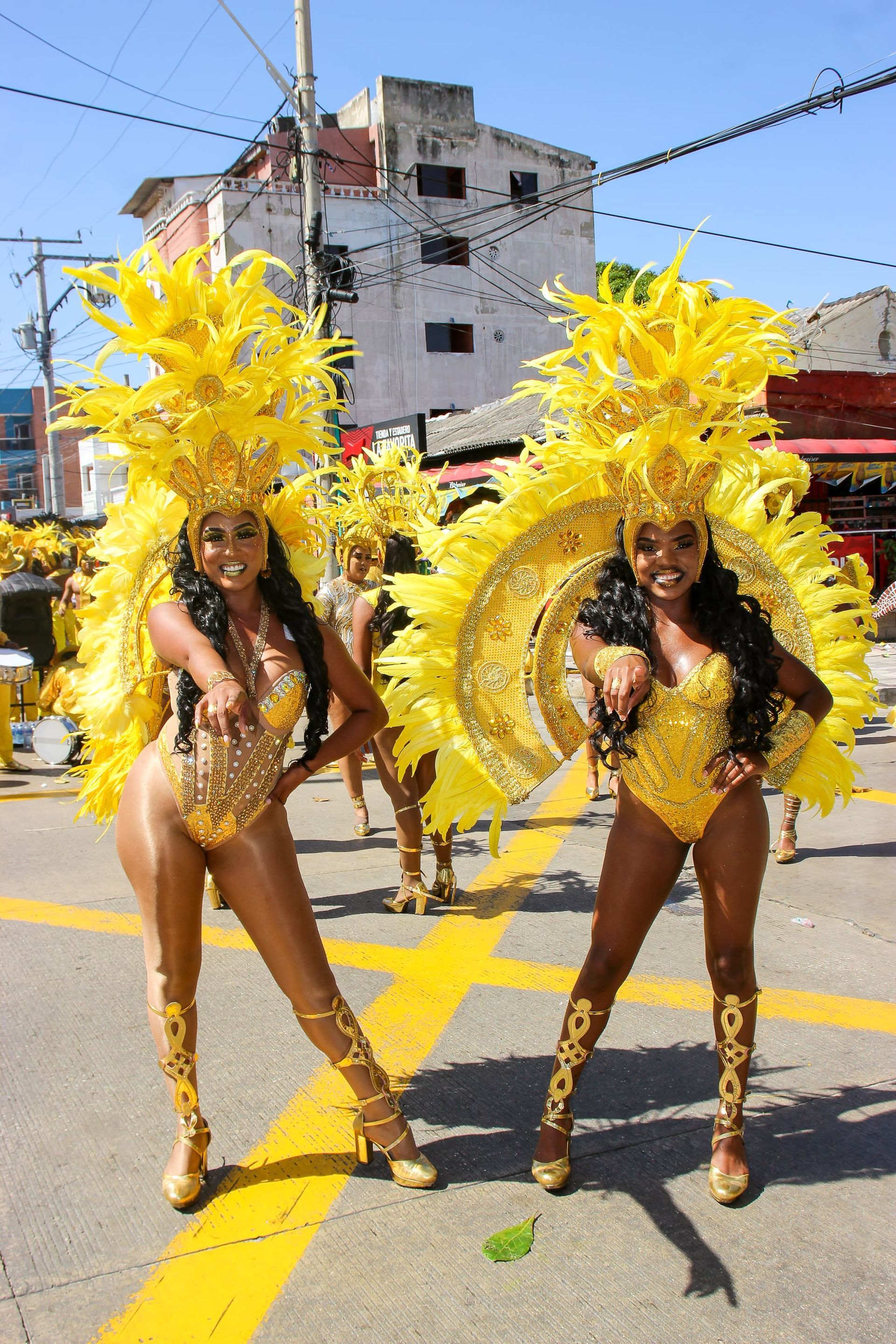 Dos mujeres con trajes amarillos están paradas una al lado de la otra en una calle.