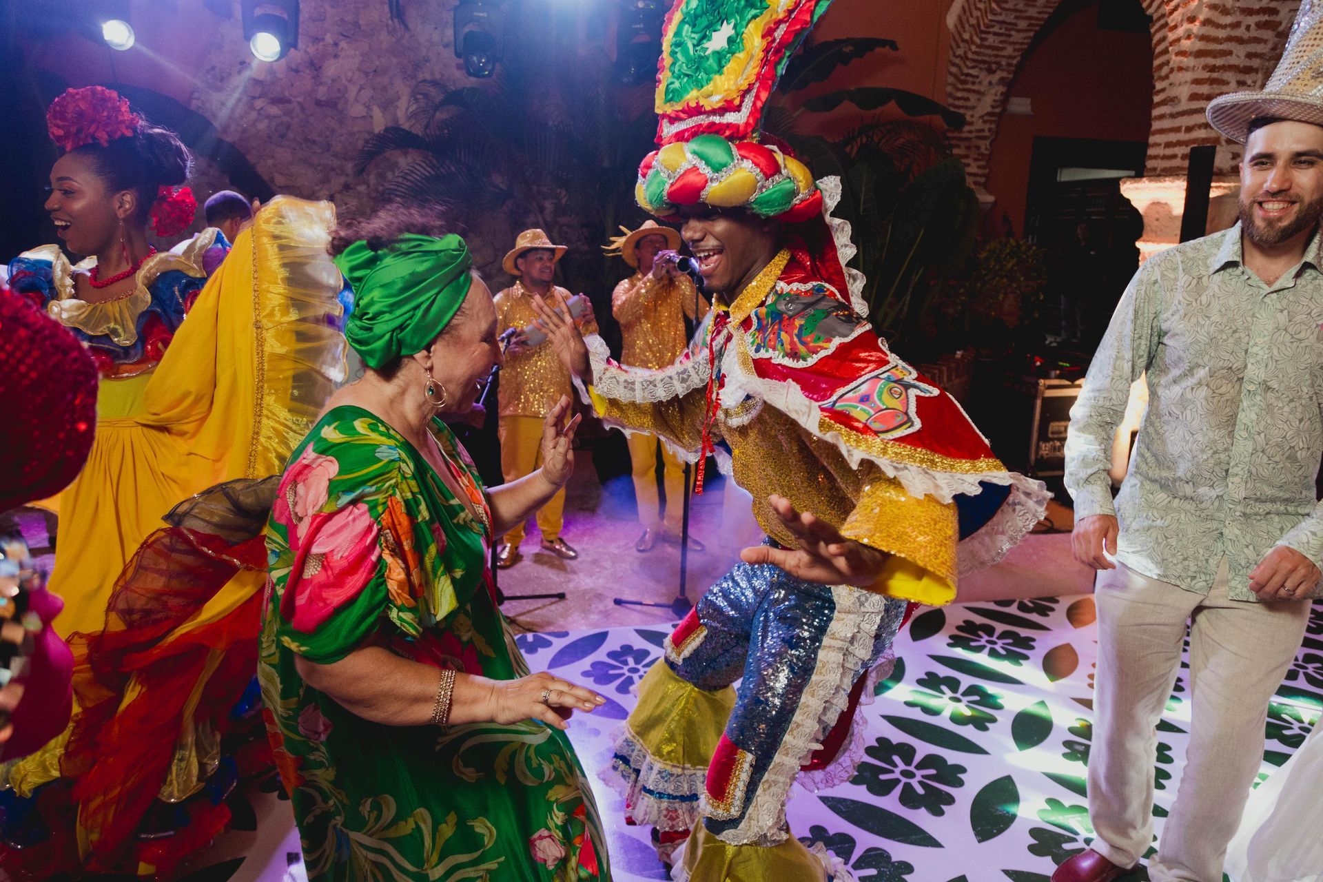 Un grupo de personas con trajes coloridos están bailando en un escenario.