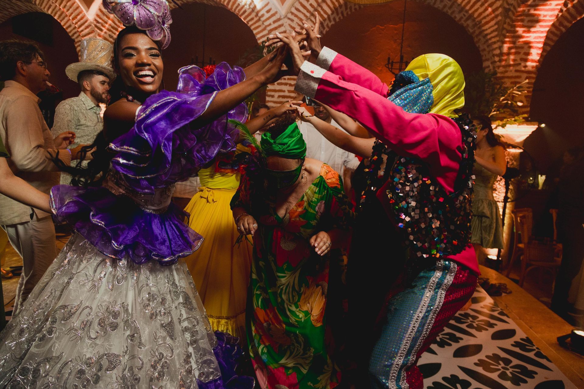 Un grupo de personas con disfraces coloridos están bailando en una habitación.
