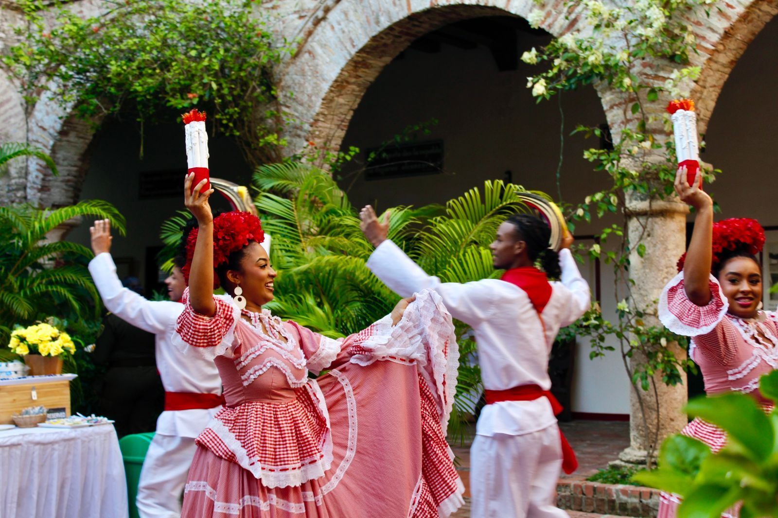 Un grupo de personas con ropas tradicionales bailan en un patio.